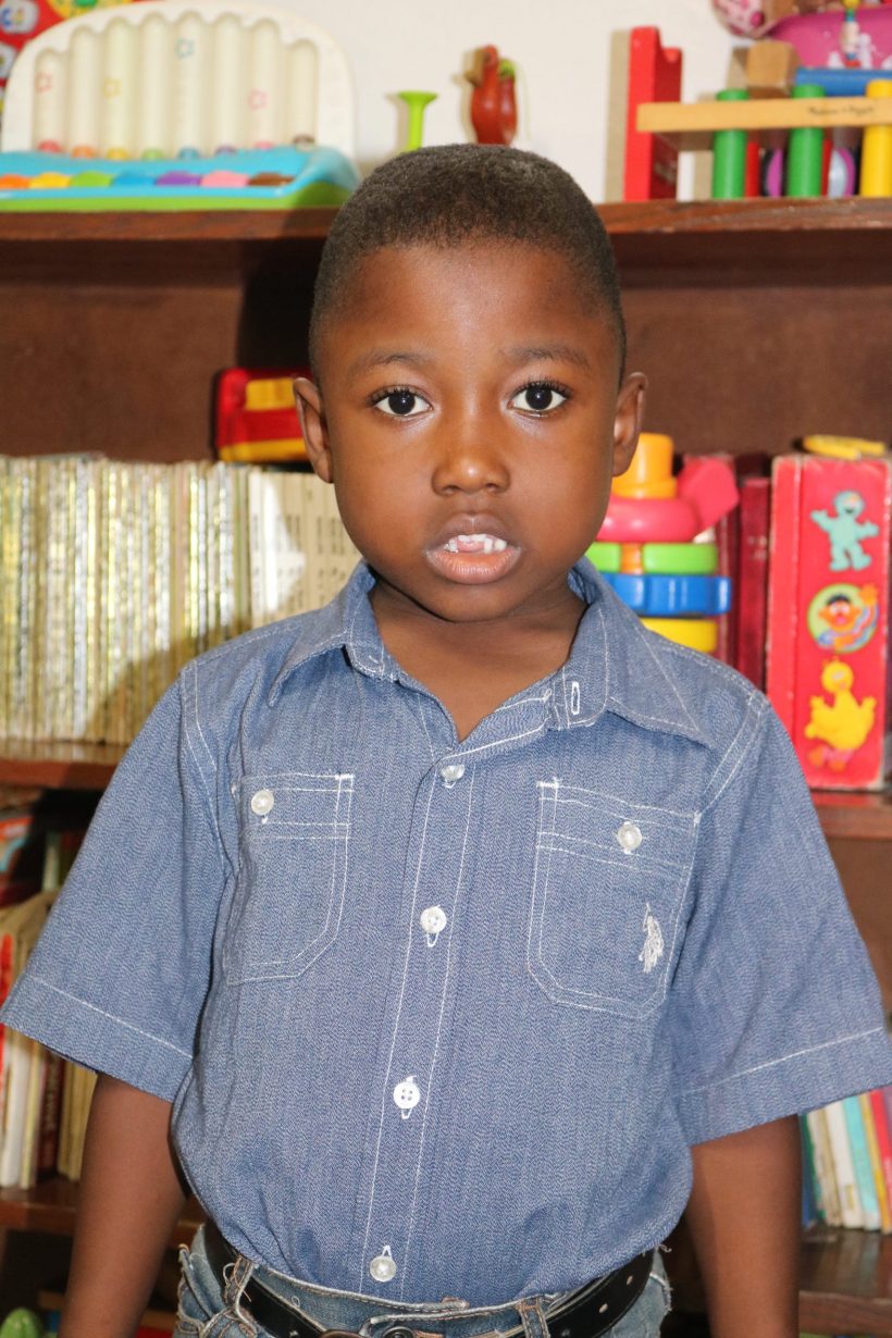 A preschool boy in a denim shirt in the classroom
